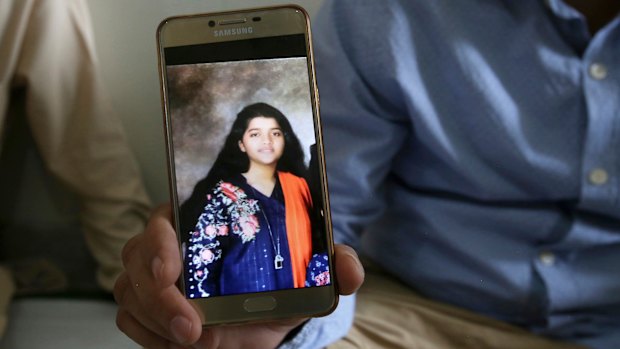 Texas high school shooting victim Sabika Sheikh's father with a  photo of his daughter. 