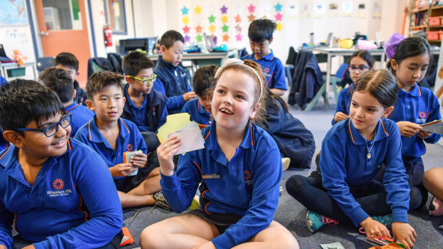 Students at Wheelers Hill Primary School, whose teacher Tim Lee has made up a currency to use in class.