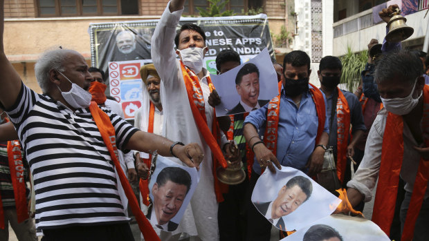 Indian activists protesting the deaths of Indian soldiers in border clashes with China burn photographs of Chinese President Xi Jinping.
