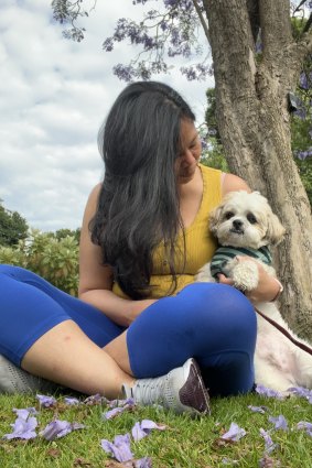 Maida Pineda relaxes under a jacaranda tree with Spark.