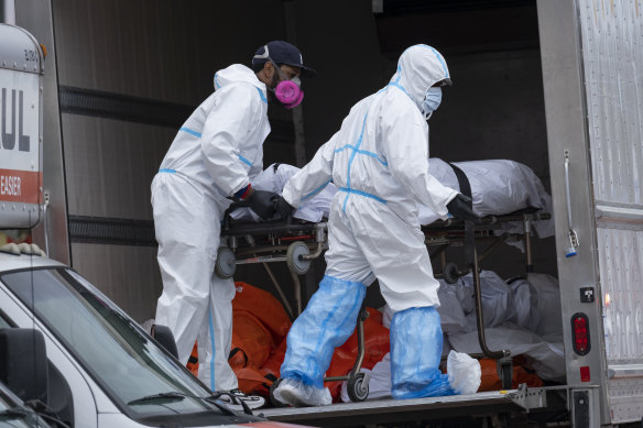 Workers move bodies to a refrigerated truck in New York in April, 2020.