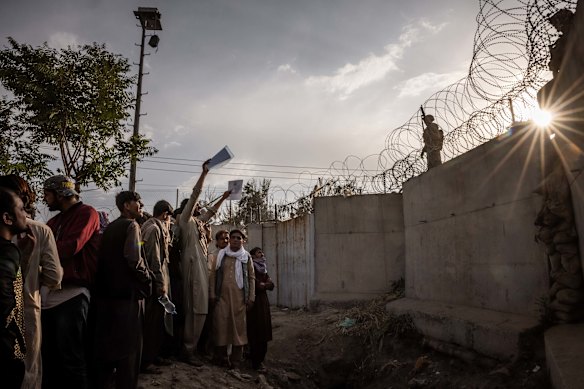 A man waves folders with documents at US Marines securing the perimeter of Kabul international airport as the US prepared to evacuate the country in August 2021.