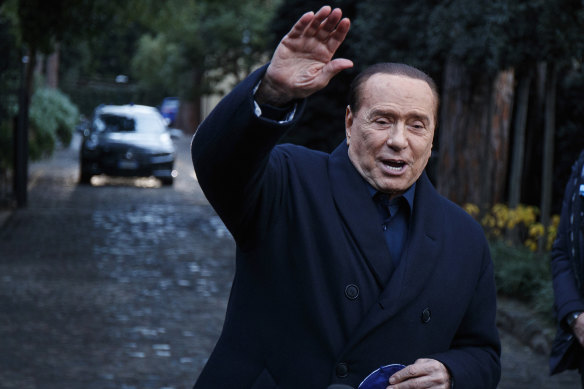 Former Italian PM Berlusconi waves to media.