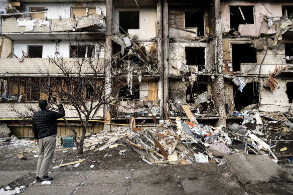 Ukrainians survey debris after a residential building was hit by missiles in the country’s capital of Kyiv.