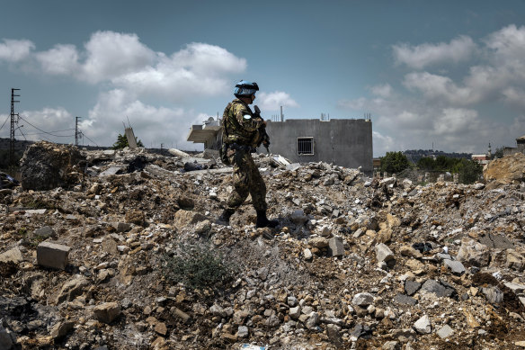 A soldier with the United Nations Interim Force inspects a house destroyed by an Israeli attack in Yarine, southern Lebanon.