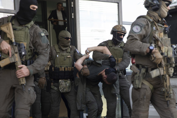 Kosovo police escort an arrested Serb gunman out of court last week.