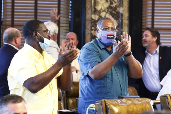 Democratic senators Juan Barnett and Robert Jackson applaud while their colleagues give each other high-fives after the Mississippi Senate passed a resolution that would allow lawmakers to change the state flag.
