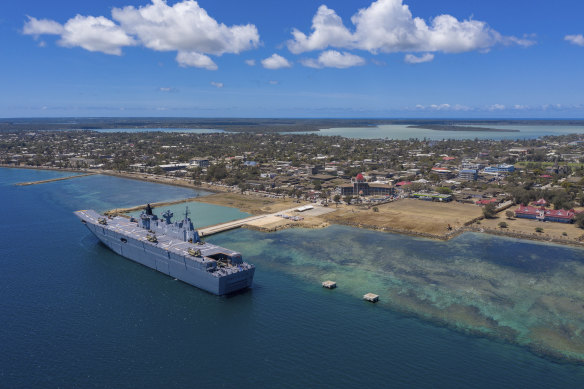 In this photo provided by the Australian Defence Force, HMAS Adelaide provides disaster aid while docked at Nuku’alofa, Tonga, on January 27. Tonga is now in lockdown after dock workers contracted COVID.