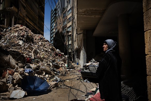 امرأة لبنانية تشاهد عندما يبحث العمال والأقارب عن المفقودين في 14 أبريل في أنقاض مبنى سكني مُدمر جراء ضربة جوية إسرائيلية قبل ستة أيام في بيروت.