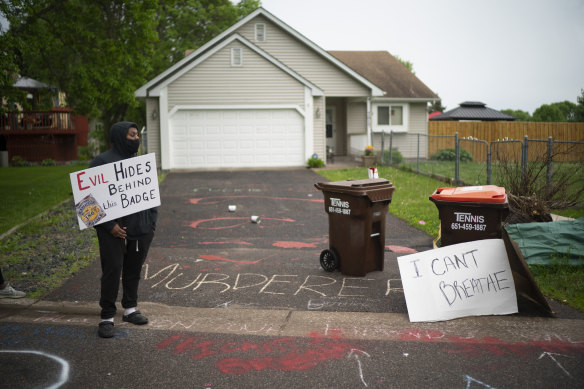 A protester stands outside Derek Chauvin’s house in May 2020. 