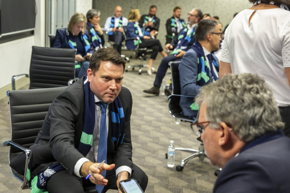 FFA chief executive James Johnson passes his phone to chairman Chris Nikou as they wait for FIFA to announce the hosts of the 2023 Women's World Cup.