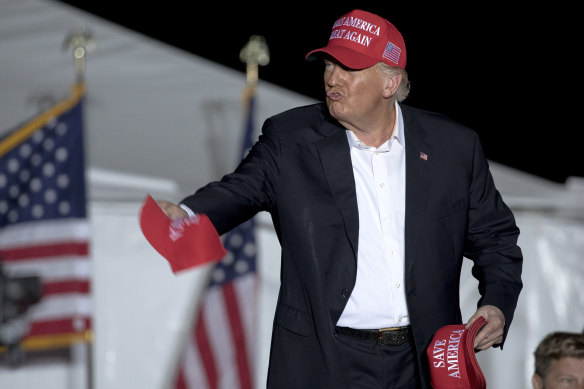 Former president Donald Trump throws hats to supporters at a rally, Saturday in Robstown, Texas.