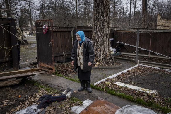 Antonina Pomazanko, 76, shows where she had buried her daughter, Tetiana, after she was killed by Russian fire in Bucha, Ukraine. Pomazanko had covered Tetiana’s body with plastic sheeting and wooden boards (seen beside her).