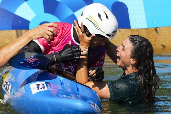 Jess Fox jumps into the water to celebrate with her sister Noemie.