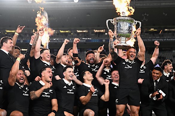 The All Blacks celebrate retaining the Bledisloe Cup.