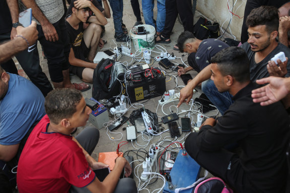 Displaced Palestinians charge their phones at a camp set up by a UN relief agency in Khan Younis, southern Gaza.