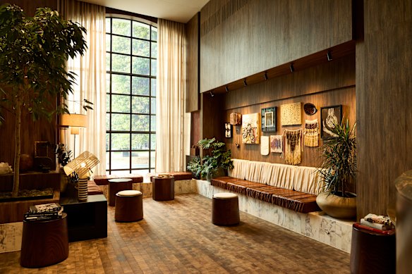 The Hotel Indigo Auckland lobby features artworks and warm-toned wood panelling.