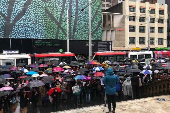 Rallygoers listen to a speaker at the steps of Sydney Town Hall on Saturday afternoon.