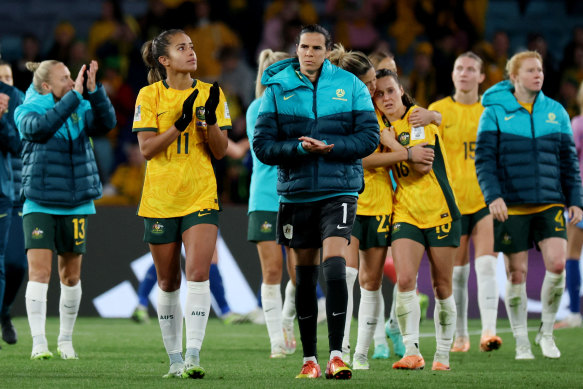 The Matildas squad applaud fans from the Stadium Australia pitch.