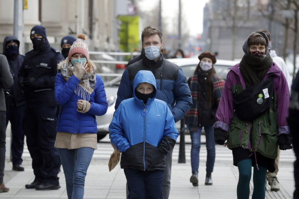 People walk on the streets of Warsaw, Poland, which has been hit by a sudden spike in new COVID-19 cases, as has much of central Europe and the Balkans.