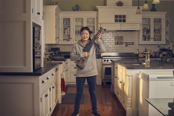 Eunju, a homemaker, holding her “favourite” gun: the Remington 870 Police Magnum 12 GA Short Barrel shotgun. 