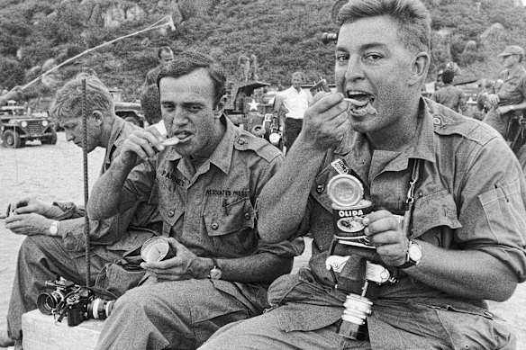 AP correspondent Peter Arnett (left) and AP staff photographer Horst Faas eat while waiting for the arrival of the US 1st Division in July 1965 in Cam Ranh Bay.  