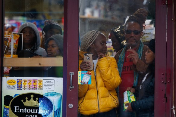 Bystanders look out from a store as law enforcement officers arrive at the scene in Jersey City, N.J. 
