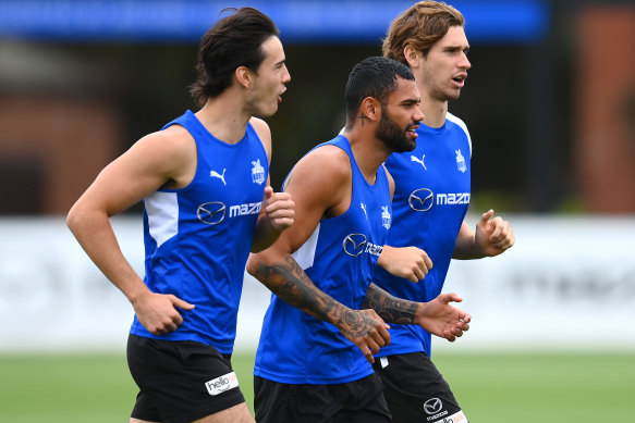 Tarryn Thomas jogs alongside teammates at North Melbourne training on Monday.