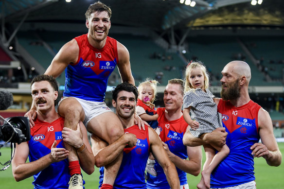 Jack Viney of the Demons is carried off for his 200th game. Max Gawn is on the far right side.