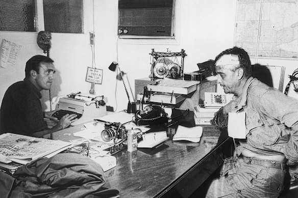 Wounded Associated Press photographer Al Chang gives an account of the battle in which he was injured at Bien Hoa to AP correspondent Peter Arnett in Saigon, December 1965.  