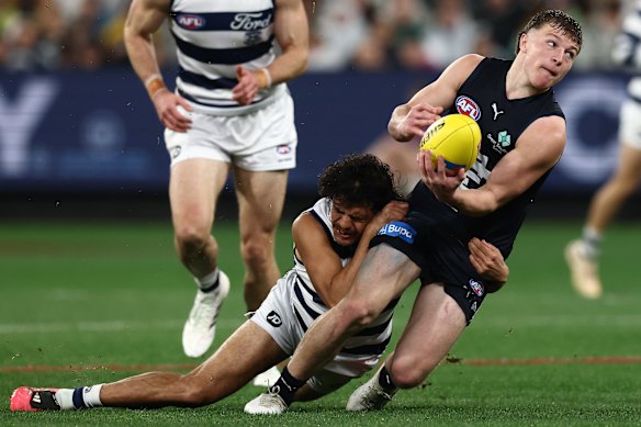 Talor Byrne of the Blues is tackled by Lawson Humphries of the Cats.