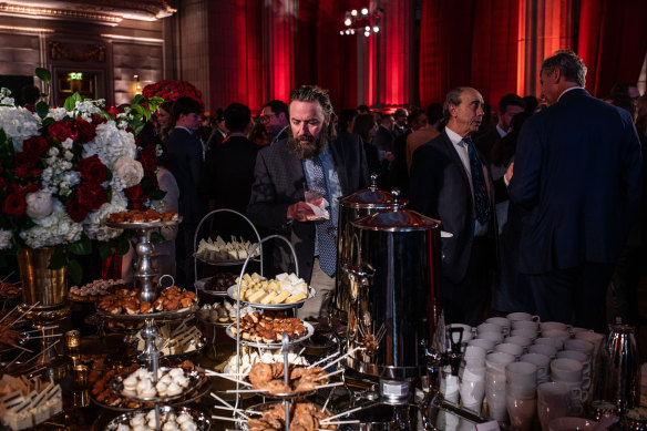 An attendee looks at a table of food at an inauguration eve celebration.