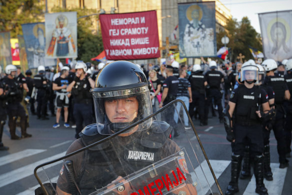 Serbian riot policemen prevent anti-gay protesters, seen holding religious banners in the background, from clashing with participants in the annual gay pride march in Belgrade, Serbia. 
