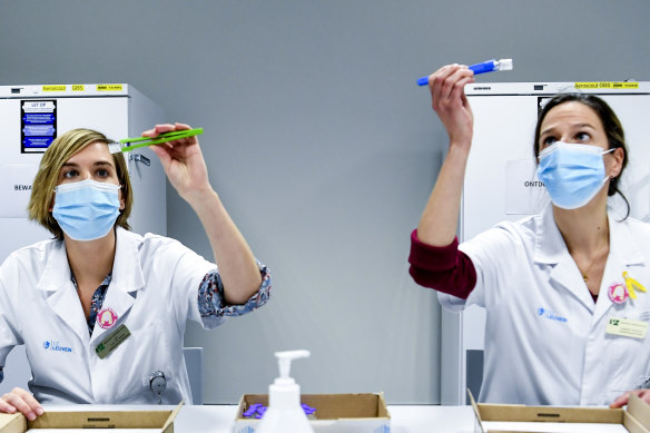 Health workers in Belgium inspect vials of the Pfizer-BioNTech coronavirus COVID-19 vaccine, which is one of the candidates expected to receive approval in Australia by the end of January.