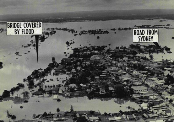 The road from Sydney (extreme right)
And the Nepean bridge (extreme left) are covered in this aerial picture showing the flooding at Windsor. November 22, 1961.
