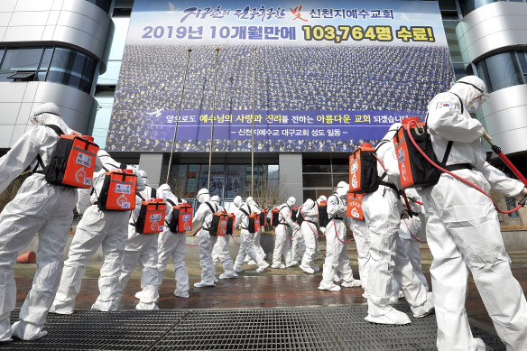 Soldiers in protective suits spray disinfectant on the steps of the Shincheonji Church of Jesus in South Korea.