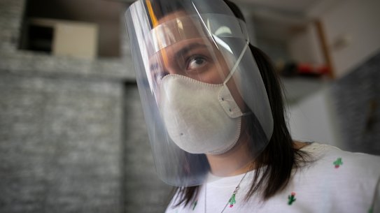 Francis Murillo, 29, wears a facial shields that she made with donated recycled materials and a 3D printer, to help prevent the spread of the new coronavirus at her shop in Caracas, Venezuela.
