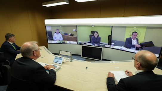 From left to right: Chief Medical Officer Professor Brendan Murphy, Prime Minister Scott Morrison and Phil Gaetjens, Secretary of the Department of Prime Minister and Cabinet, speak with (on screen left to right) Jim McDowell, Chief Executive of the South Australia Department of Premier and Cabinet, Premier of NSW Gladys Berejiklian and Premier of Western Australia Mark McGowan during a national cabinet meeting at Parliament House in Canberra.