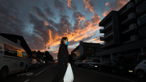 A Victorian government worker carries food into a locked down apartment complex in Melbourne’s north-west.