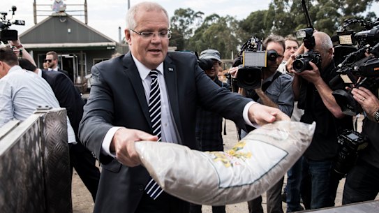 Prime Minister Scott Morrison moves some mulch at Daisy’s Garden Supplies in Ringwood on Monday.