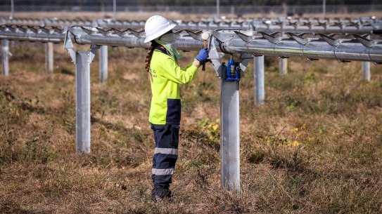 A worker checks newly constructed metal frames for photovoltaic solar farm. Many people think markets should dictate where