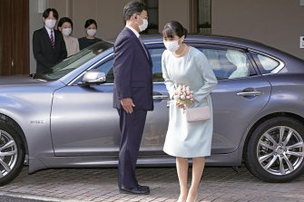 Princess Mako bows before leaving her home in Akasaka Estate in Tokyo. Standing in the background are from left, her parents Crown Prince Akishino, Crown Princess Kiko and her sister Princess Kako.