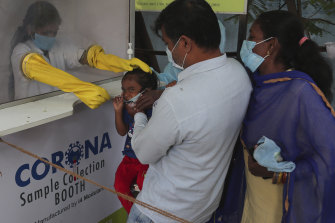 A health worker takes a nasal swab sample from a child at a COVID-19 testing centre in Hyderabad, India.