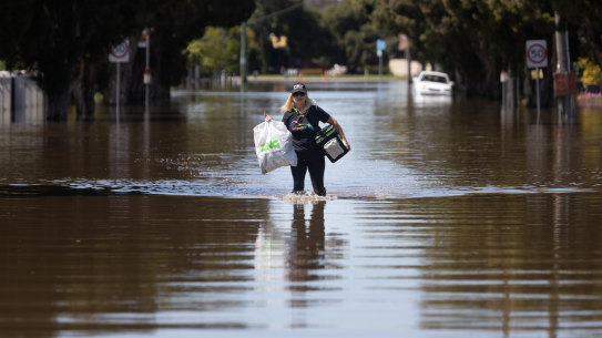 A woman carries her belongings through the floodwater in South Shepparton on Monday.