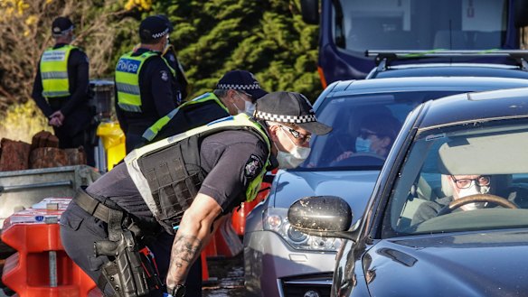 Victoria Police members stop motorists leaving metropolitan Melbourne on Sunday.