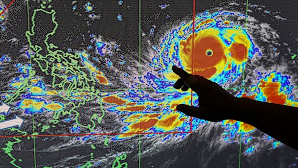 Filipino forecaster Meno Mendoza illustrates the path of typhoon Mangkhut.