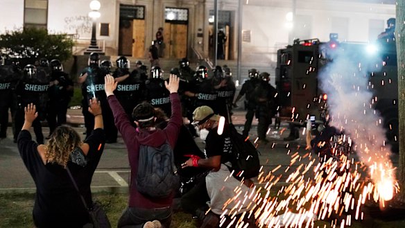 Police attempt to push back protesters outside the Kenosha County Courthouse.