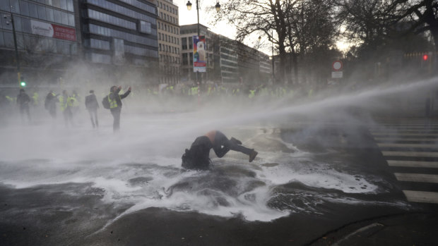A water cannon is used on a yellow jacket protester in Brussels.