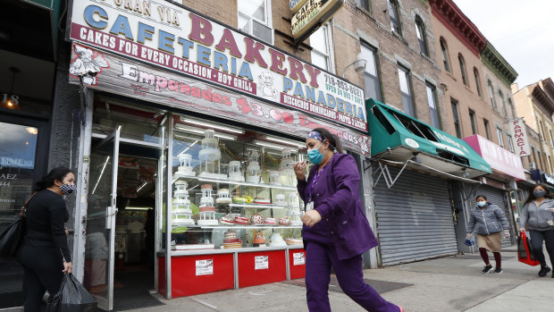 A woman talks on her phone as she walks past a bakery in the Sunset Park neighbourhood of the Brooklyn borough of New York.