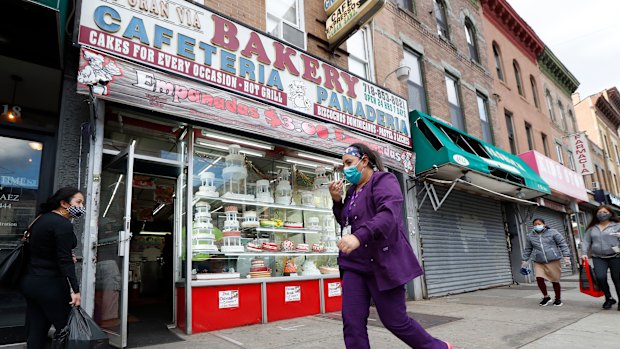 A woman talks on her phone as she walks past a bakery in the Sunset Park neighbourhood of the Brooklyn borough of New York.